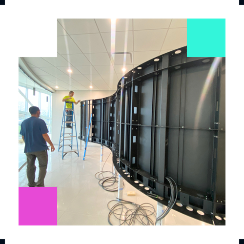 Person in glasses speaking at podium with microphone and book.