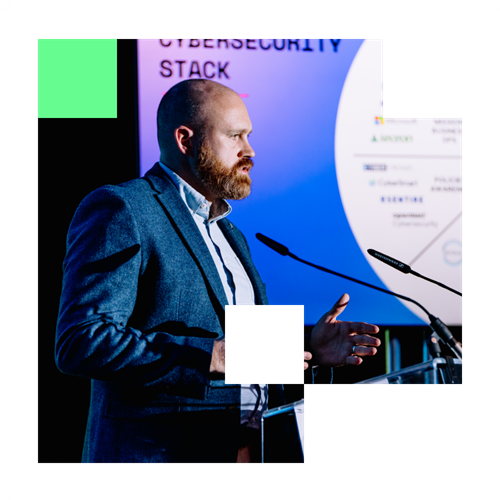 Man speaking at podium with slide titled Cybersecurity Stack.