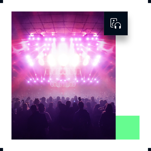 Large audience at concert with pink and purple stage lights.